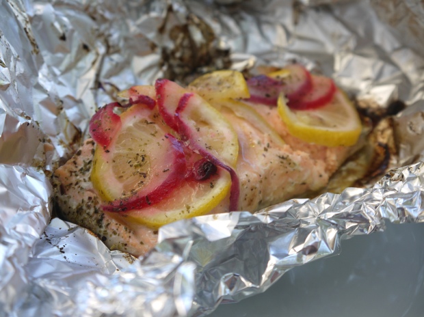 Salmon on the barbecue with red onion and lemon